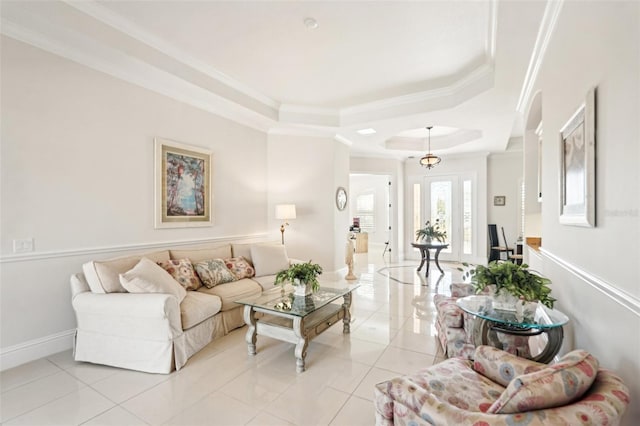 living area with baseboards, a raised ceiling, light tile patterned flooring, and crown molding