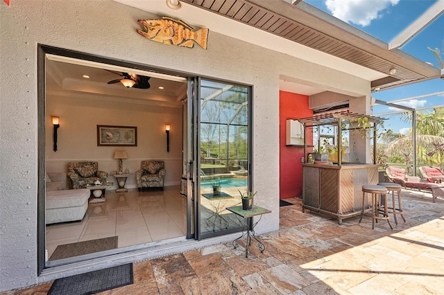 entrance to property with outdoor dry bar, stucco siding, and a patio