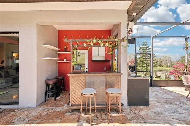 bar featuring stone tile floors and indoor bar