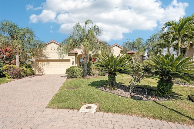 view of front of house featuring stucco siding, a front lawn, a garage, and driveway