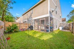 back of house featuring a yard and a fenced backyard