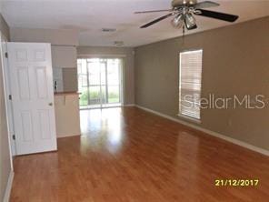 empty room with ceiling fan, baseboards, and wood finished floors