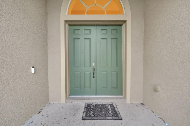 view of exterior entry featuring stucco siding