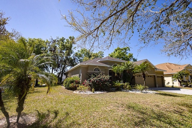 view of front of property featuring concrete driveway, a garage, a front lawn, and stucco siding