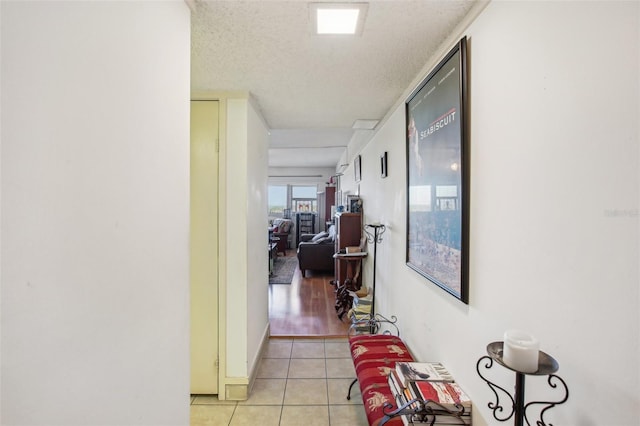 hallway featuring light tile patterned floors and a textured ceiling