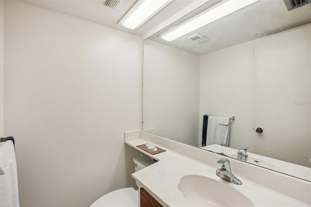 bathroom featuring visible vents, toilet, and vanity