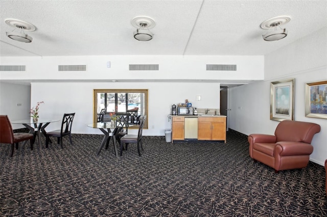 interior space with visible vents, dishwasher, and dark carpet