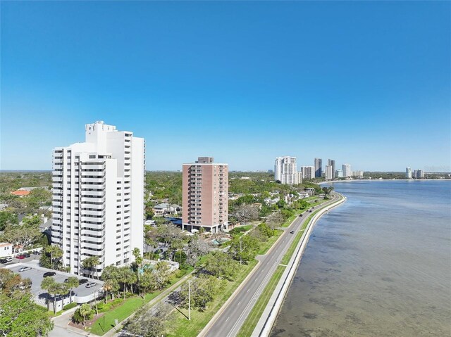 drone / aerial view featuring a city view and a water view