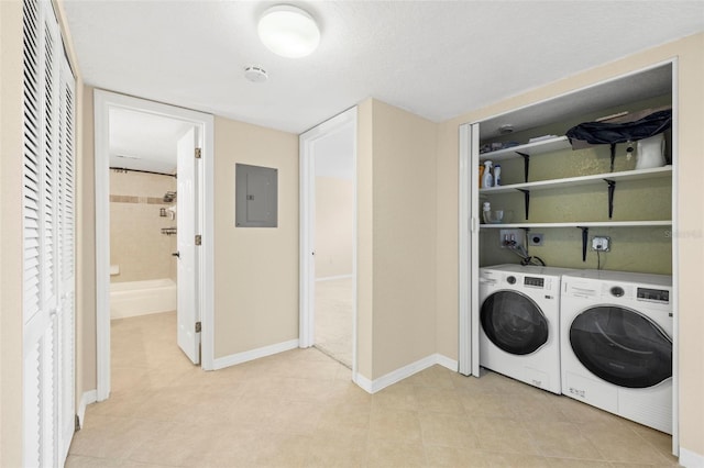 clothes washing area with electric panel, laundry area, washer and dryer, and baseboards