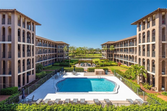 community pool featuring a patio and fence