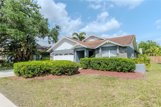 14501 Brambie Ct, Tampa, FL 33624 - single story home featuring stone siding, an attached garage, fence, and a front lawn