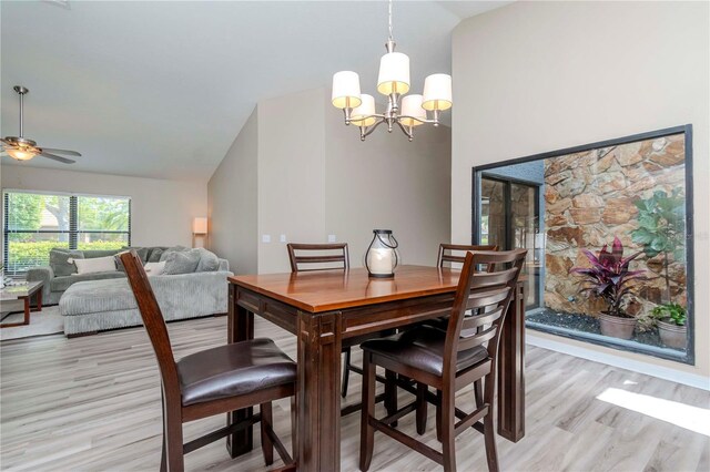 14501 Brambie Ct, Tampa, FL 33624 - dining room with ceiling fan with notable chandelier, lofted ceiling, and light wood-type flooring