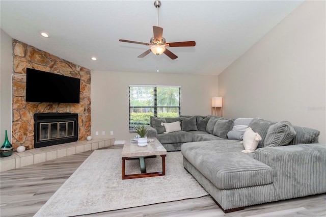 14501 Brambie Ct, Tampa, FL 33624 - living area featuring wood finished floors, a stone fireplace, lofted ceiling, and ceiling fan