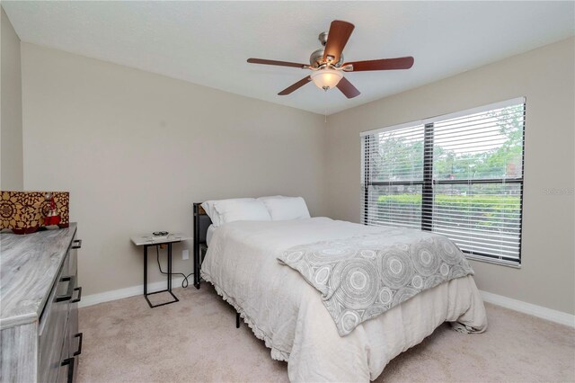 14501 Brambie Ct, Tampa, FL 33624 - bedroom with light colored carpet, ceiling fan, and baseboards