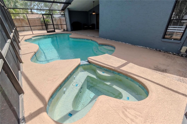 14501 Brambie Ct, Tampa, FL 33624 - view of pool with a patio, fence, a pool with connected hot tub, and glass enclosure