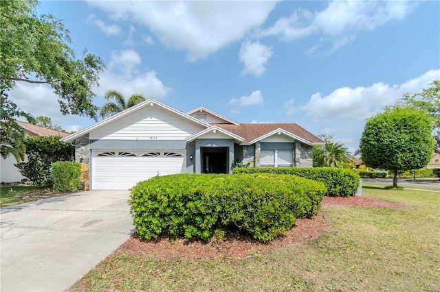 14501 Brambie Ct, Tampa, FL 33624 - ranch-style house featuring a front lawn, stone siding, a garage, and concrete driveway