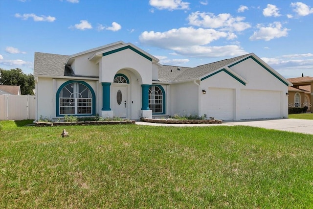 view of front of home featuring a front yard, driveway, an attached garage, and stucco siding