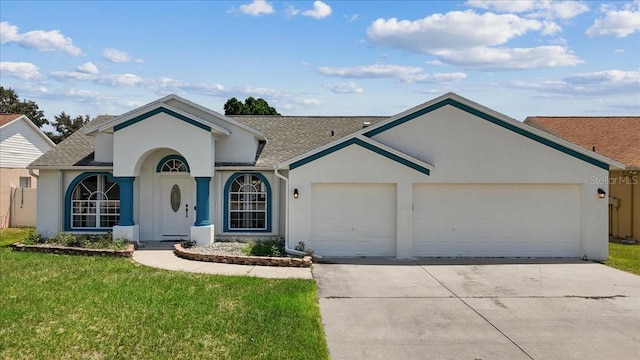 ranch-style house with a garage, concrete driveway, roof with shingles, stucco siding, and a front yard