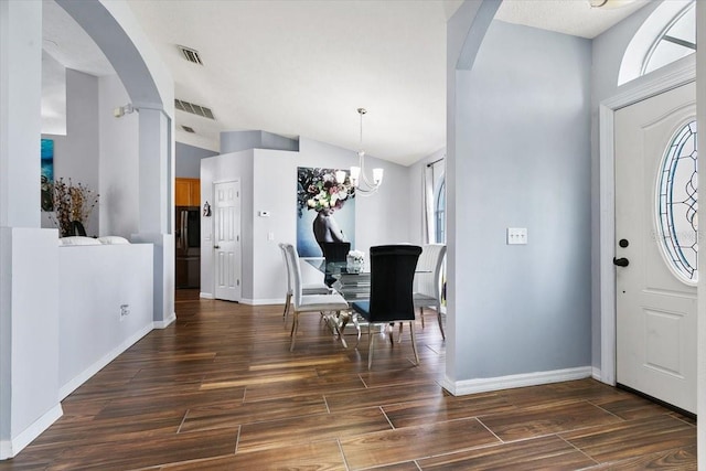 entryway with lofted ceiling, visible vents, arched walkways, and wood finished floors