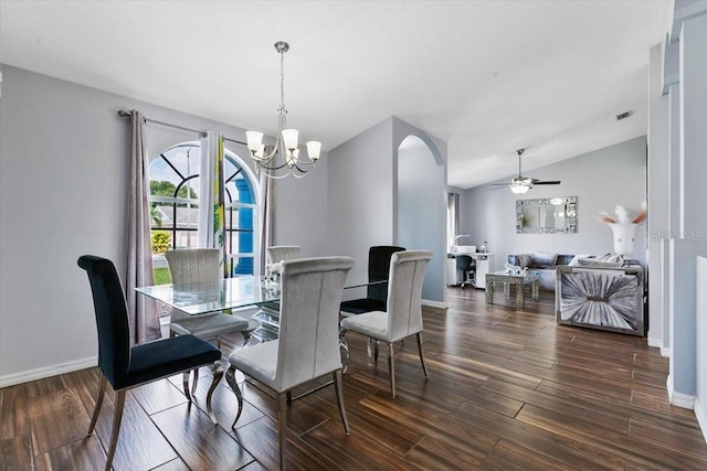 dining space featuring lofted ceiling, ceiling fan with notable chandelier, wood finished floors, visible vents, and baseboards