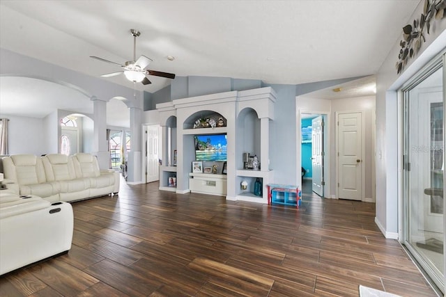 living room featuring arched walkways, vaulted ceiling, wood finished floors, and a ceiling fan