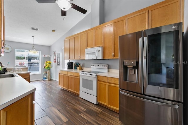 kitchen with lofted ceiling, light countertops, dark wood-type flooring, a sink, and white appliances