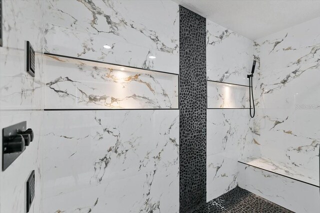 full bathroom featuring a marble finish shower