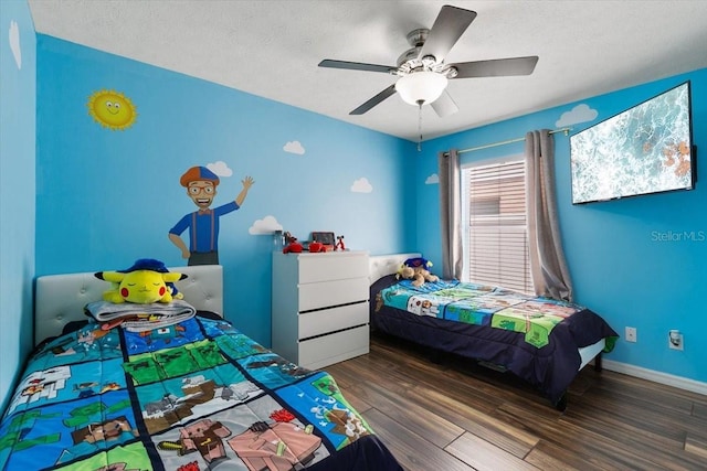 bedroom with a textured ceiling, wood finished floors, a ceiling fan, and baseboards