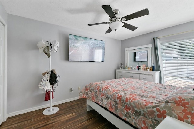 bedroom with dark wood finished floors, a ceiling fan, and baseboards