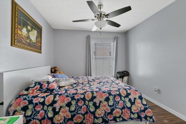 bedroom featuring ceiling fan, baseboards, and wood finished floors