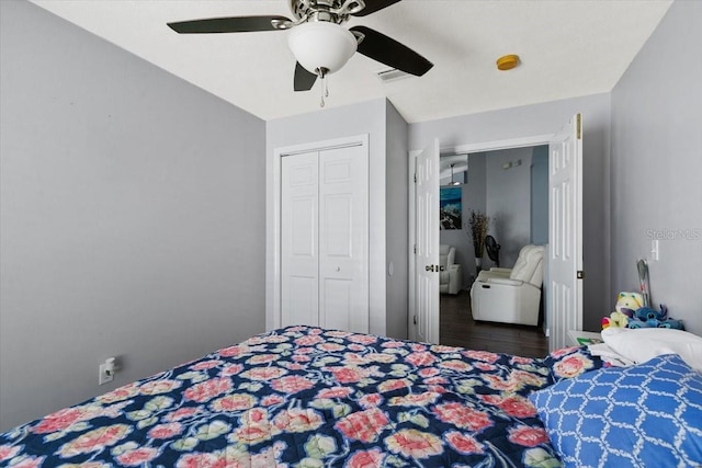 bedroom with ceiling fan, a closet, wood finished floors, and visible vents