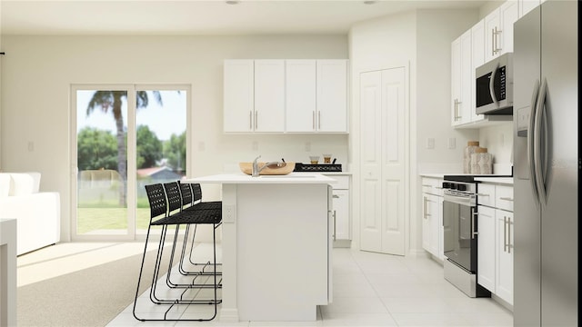 kitchen with stainless steel appliances, a breakfast bar, light countertops, and white cabinetry