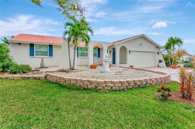 view of front of house with stucco siding, a front yard, metal roof, a garage, and driveway