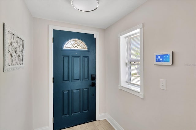 entryway with light wood-style flooring and baseboards