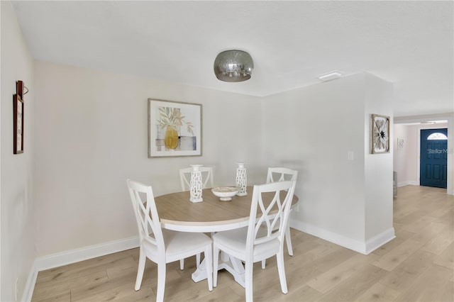 dining space with visible vents, light wood-style flooring, and baseboards