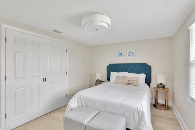 bedroom featuring light wood finished floors, multiple windows, and visible vents