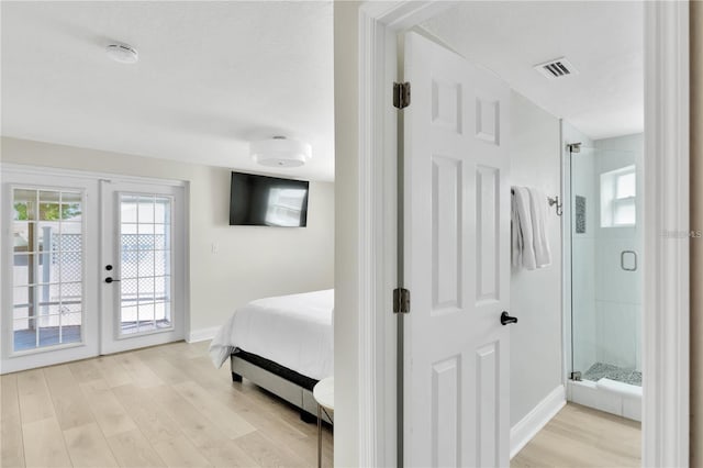 bedroom featuring access to outside, multiple windows, and light wood-style flooring