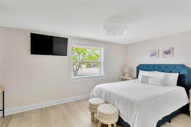 bedroom with baseboards and wood finished floors