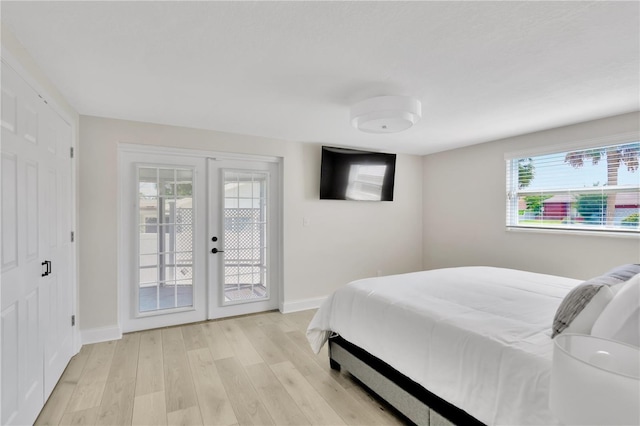 bedroom with baseboards, french doors, light wood-style floors, and access to exterior