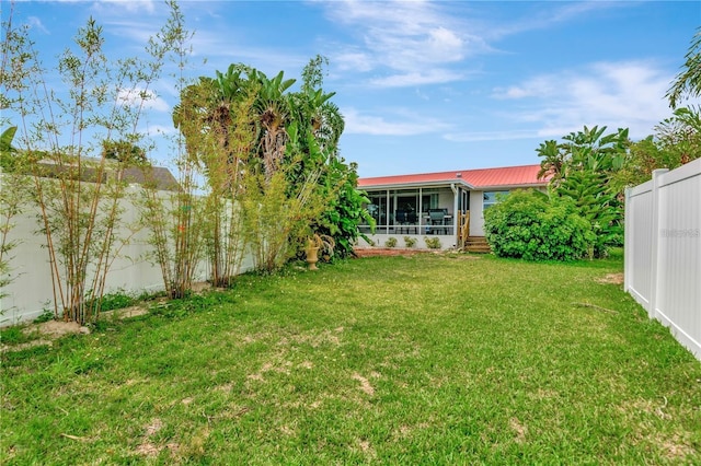 view of yard featuring a sunroom and a fenced backyard