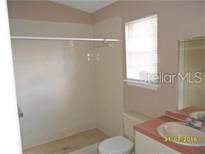 full bathroom with toilet, walk in shower, and vanity