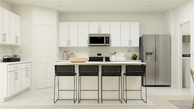 kitchen with a kitchen island, a breakfast bar, stainless steel appliances, white cabinetry, and light tile patterned flooring