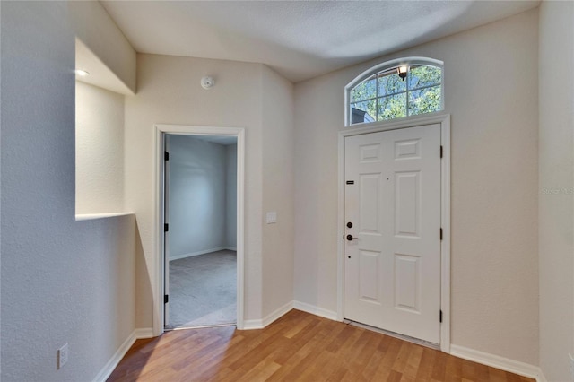 entrance foyer featuring light wood finished floors and baseboards