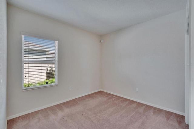 empty room with light colored carpet and baseboards