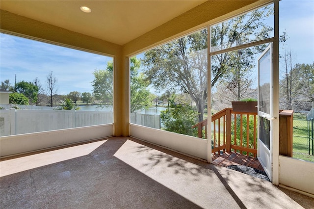 unfurnished sunroom with a water view