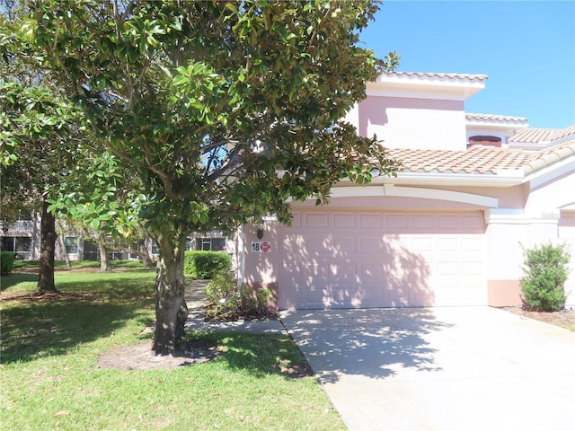 view of front facade with a garage, concrete driveway, a tiled roof, a front lawn, and stucco siding