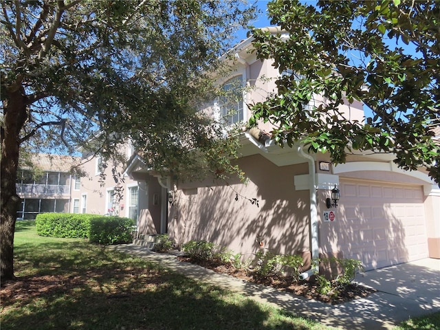 view of side of home featuring driveway and stucco siding