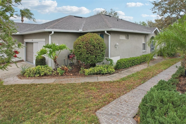 view of home's exterior with stucco siding, a garage, driveway, and a shingled roof