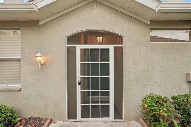 entrance to property featuring stucco siding