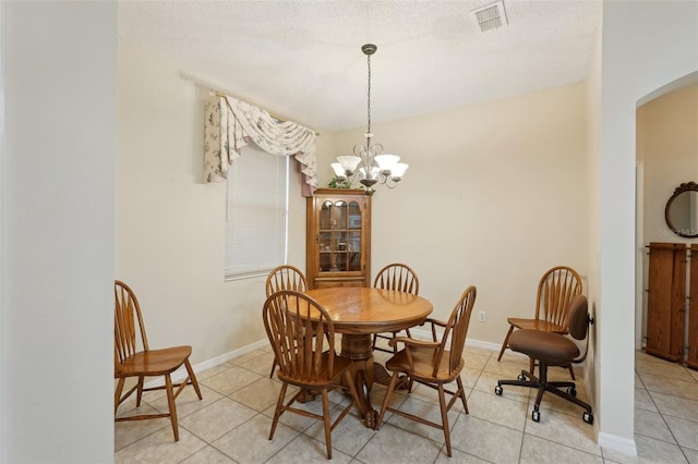 dining area with light tile patterned floors, visible vents, baseboards, an inviting chandelier, and arched walkways